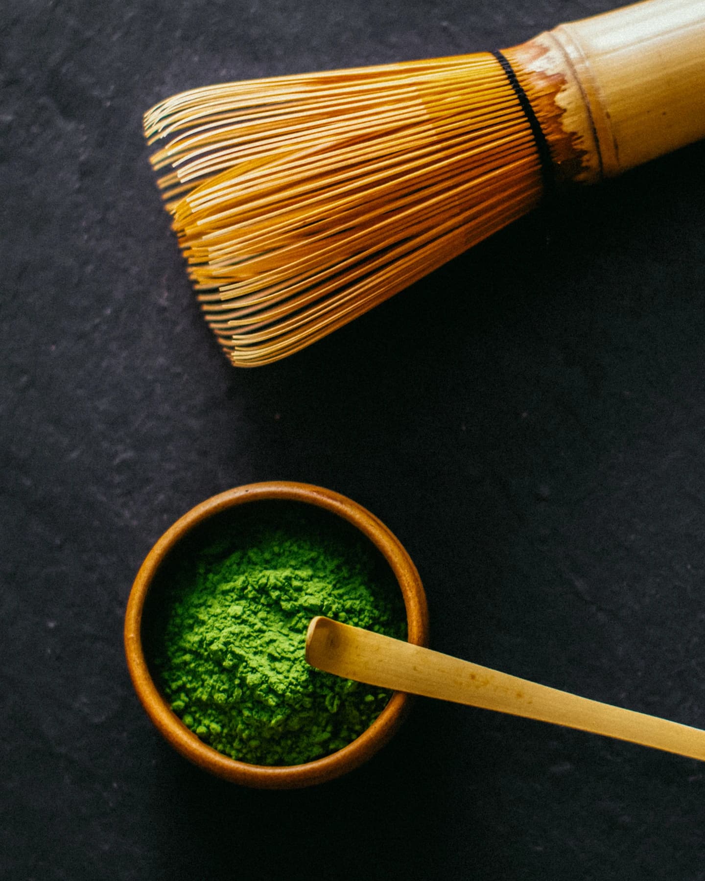 Matcha powder and a bamboo whisk